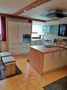 a kitchen with white cabinets and a large island at Ferienwohnung Neuhaus in Nittenau