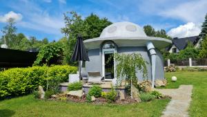 a small dome house with an umbrella in a yard at Chata w Rabce - Bajkowa Osada in Rabka
