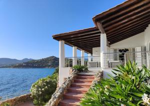 a house with stairs leading to the water at Villa Bella in Torre delle Stelle