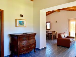 a living room with a wooden dresser and a chair at Casa Maria in Moncarapacho