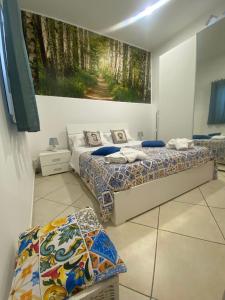 2 camas en una habitación con un cuadro en la pared en La casa di Andrea, en Fiumefreddo di Sicilia