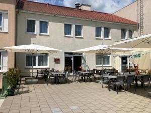 a patio with tables and umbrellas in front of a building at Kolpingsfamilie Poysdorf in Poysdorf