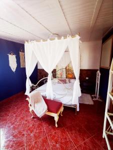 a bedroom with a canopy bed and a chair at Kikiki House in Puerto del Rosario