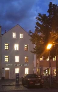une voiture garée devant un bâtiment la nuit dans l'établissement Altstadthotel Alt & Jung, à Ratisbonne