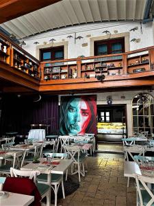 un restaurante con mesas y una pintura de una cara en la pared en KEYİFTE Alaçatı, en Alacati