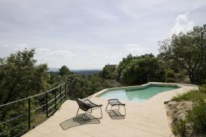 eine Terrasse mit 2 Stühlen und einem Pool in der Unterkunft Consolación in Monroyo