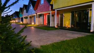 szereg kolorowych domów w nocy w obiekcie Kolorowe Domki w Gąskach
