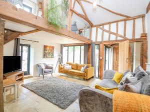 a living room with a couch and a tv at Hargate Farm Barn in Norwich