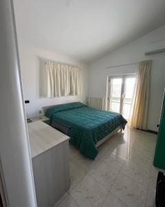 a bedroom with a green bed and a window at B&B Le Terrazze in Crotone