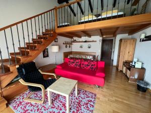 a living room with a red couch and a staircase at Ascona: Sabrina Apt.238 in Ascona