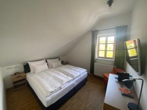 a bedroom with a white bed and a window at Altstadthotel Alt & Jung in Regensburg