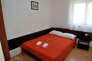 Apartments Popovac 736 في غراداك: غرفة نوم عليها سرير وفوط بيضاء