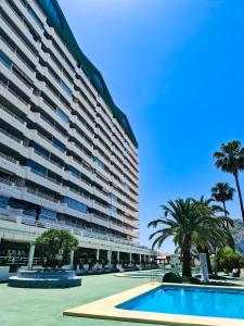 duży apartamentowiec z basenem i palmami w obiekcie AVANOA - Esmeralda Calpe w mieście Calpe