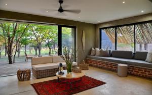 ein Wohnzimmer mit einem Sofa und einem Tisch in der Unterkunft Ngala Lodge in Klipdrift