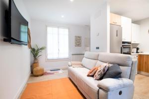 a living room with a couch and a tv at La casa de la brujita with AC in San Sebastián