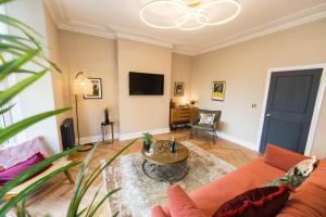una sala de estar con un sofá y una mesa en Maison Mouettes by Luxury Travel Emporium - Luxury Suites with Abbey Views, en Whitby