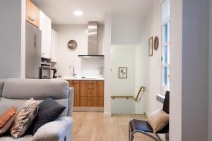 a living room with a couch and a kitchen at La casa de la brujita with AC in San Sebastián