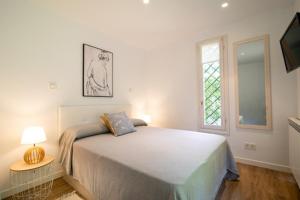 a white bedroom with a bed and a window at La casa de la brujita with AC in San Sebastián