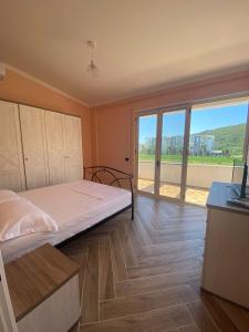 1 dormitorio con cama y ventana grande en Tea Residence, Gjiri i Lalzit Apartments en Durrës