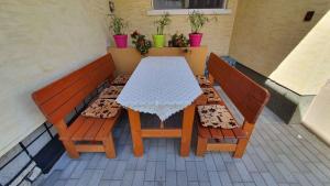 un tavolo e due panche su un patio di Apartment in Zamardi - Balaton 20318 a Zamárdi