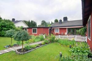 ein rotes Haus mit einem Garten davor in der Unterkunft Private Room in Shared House-Close to University and Hospital-3 in Umeå