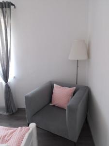 un sofá gris con una almohada rosa en una habitación en APARTMENT WITH A VIEW, en Bohinjska Bistrica