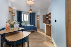 salon z łóżkiem i stołem oraz kuchnia w obiekcie Zielona Apartment Grzybowo by Renters w Grzybowie