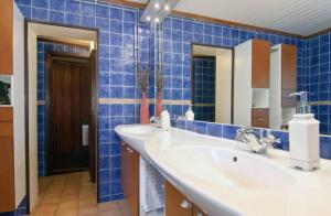 a blue tiled bathroom with two sinks and two mirrors at Private Room in Shared House-Close to University and Hospital-3 in Umeå