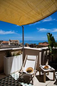 balcone con tavolo, sedia e ombrellone di NITI Palace a Castellammare del Golfo