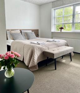 a bedroom with a bed and a table and a vase of flowers at Hos Martin - Bed and Tee Kitchen - Kontaktløst - Contactless in Sindal