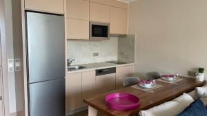 uma cozinha com uma mesa de madeira e um frigorífico em Green Garden City Luxury Apartments em Alanya