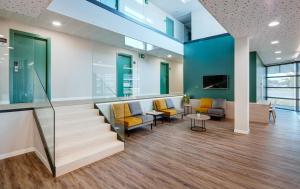 an office lobby with a staircase and chairs at Sercotel Córdoba Delicias in Córdoba