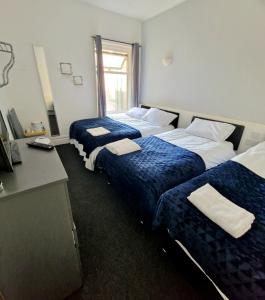 a hotel room with two beds and a desk at The Bosworth House Hotel in Blackpool
