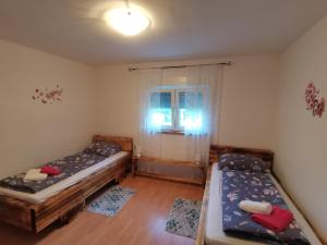 two beds in a room with a window at Vila Bella in Plitvička Jezera