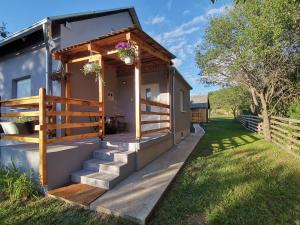 ein kleines Haus mit einer Treppe, die auf eine Veranda führt in der Unterkunft Vila Bella in Plitvička Jezera
