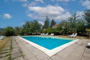 a swimming pool with chairs and a house at Casale I Cascetti in Piancastagnaio