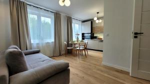 a living room with a couch and a table at Apartament Arkadia Augustow in Augustów