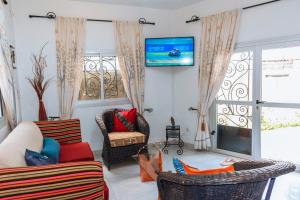 sala de estar con sillas y TV en la pared en MOOKSQUARE NS SPOT, en Douala