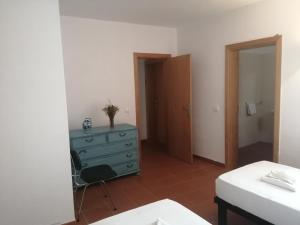 a bedroom with a blue dresser and a blue cabinet at Casa da Osga in Tavira