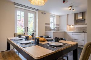 a kitchen with a wooden table and a dining room at Leven in Windermere
