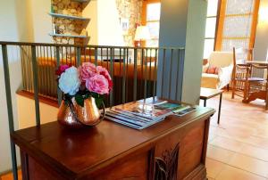 un jarrón de flores sobre una mesa en la sala de estar en Casa rural con jardín privado, en Navata