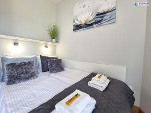 a bedroom with a bed with towels on it at 365PAM - Apartament LET'S SEA z widokiem na morze - BASEN, JACUZZI, SAUNA, SIŁOWNIA, STREFA CHILL, PARKING W CENIE in Gąski +32 photos