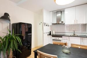 a kitchen with a table and a black refrigerator at WOW Apartments by Olala Homes in El Arrabal