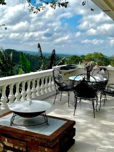 a patio with chairs and a table on a balcony at Pondok Plantation Luxury Mountain Escape Bedugul in Bedugul