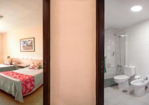 a bedroom with a bed and a bathroom with a toilet at Apartamentos las Góndolas in Playa del Ingles