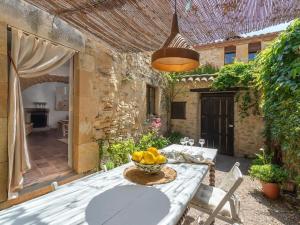 Preciosa casa rural en el centro de Peratallada في بيرتايادا: فناء مع طاولة مع وعاء من الفواكه