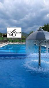 - une piscine avec un parasol dans l'eau dans l'établissement Lileya Hotel, à Polyana