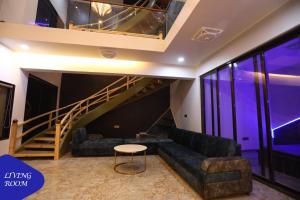 - un salon avec un canapé et un escalier dans l'établissement Royal Twin - 12BHK Luxury Villa by Royal Villa's Lonavla, à Lonavala