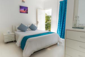 una camera da letto con un letto con tende blu e una finestra di Palm Gate Maldives a Thulusdhoo