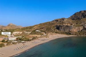 una vista aérea de una playa con sillas y el océano en Paligremnos Residences, a Beachside Retreat, By ThinkVilla, en Plakias